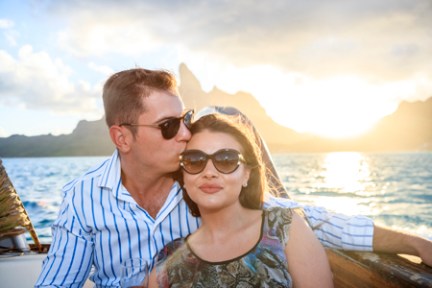 a man and woman sitting next to a body of water